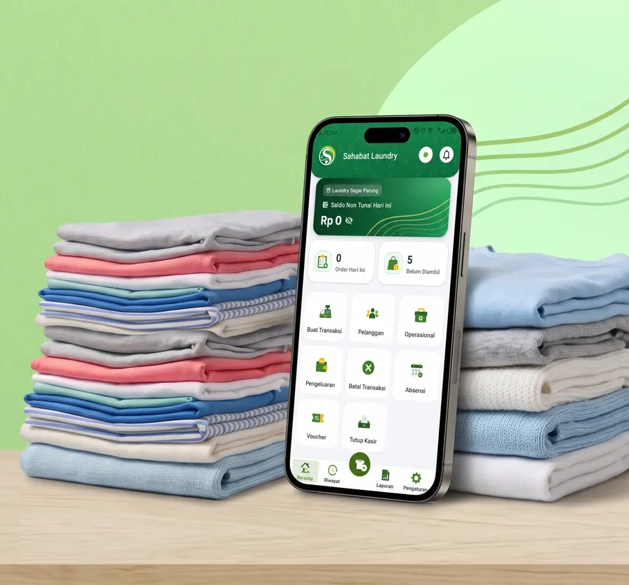 Tumpukan cucian terlipat di atas meja, di sebelahnya ponsel yang menampilkan layar Beranda aplikasi Sahabat Laundry